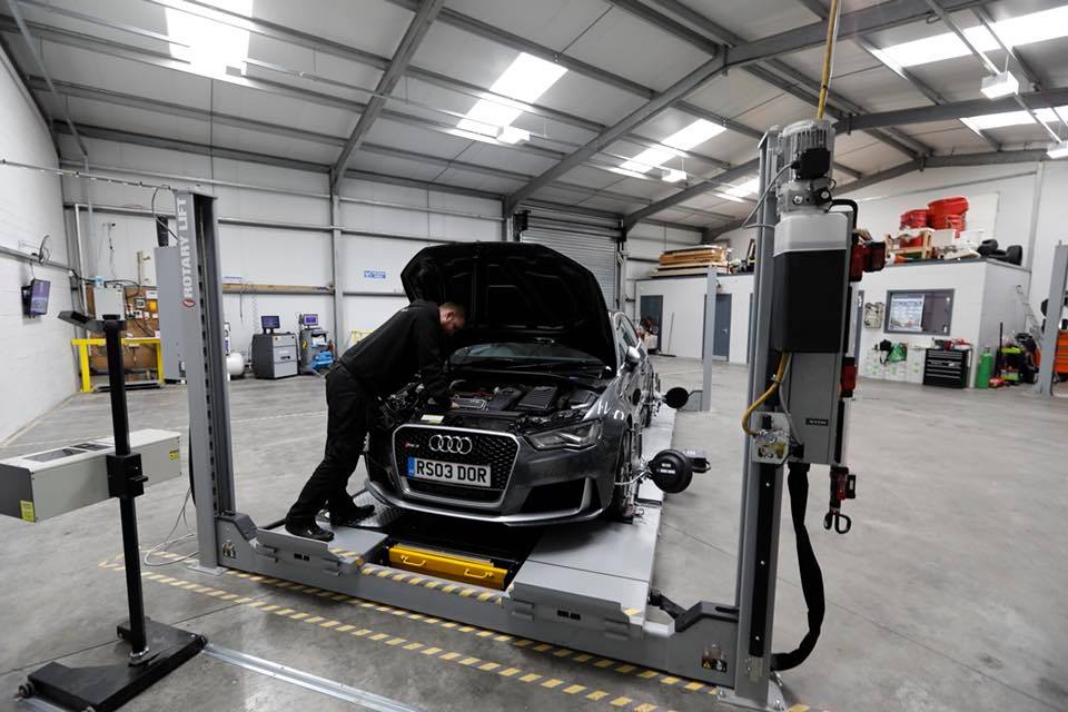 Technician diagnosing an Audi on the alignment lift in the PLA Automotive workshop, Bathgate